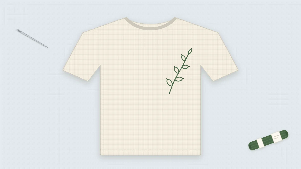 Plain cream T-shirt laid flat with a small embroidered leaf sprig on the left chest